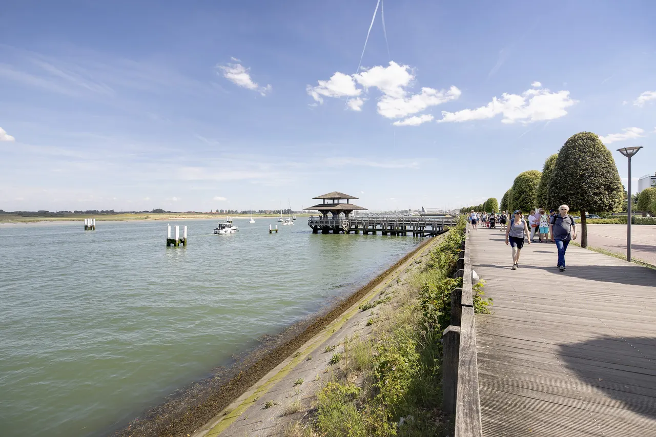 Wandelaars op de dijk langs de IJzermonding in Nieuwpoort.