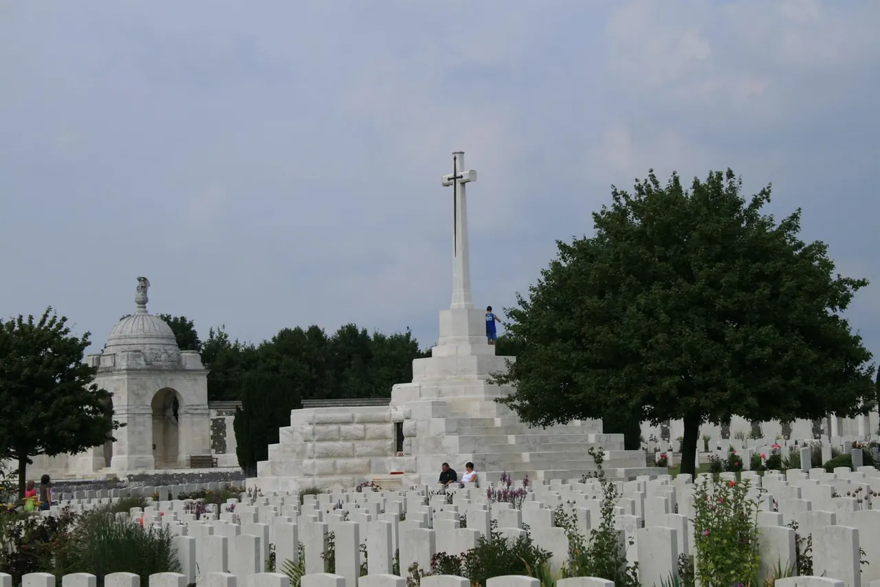 De witte grafstenen en het Cross of Sacrifice op Tyne Cot Cemetery.