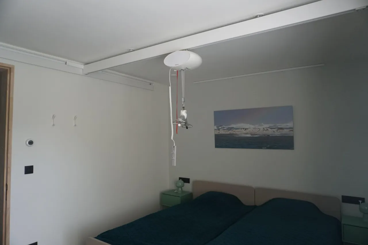 De plafondtillift aan de rail boven de bedden in slaapkamer 1.